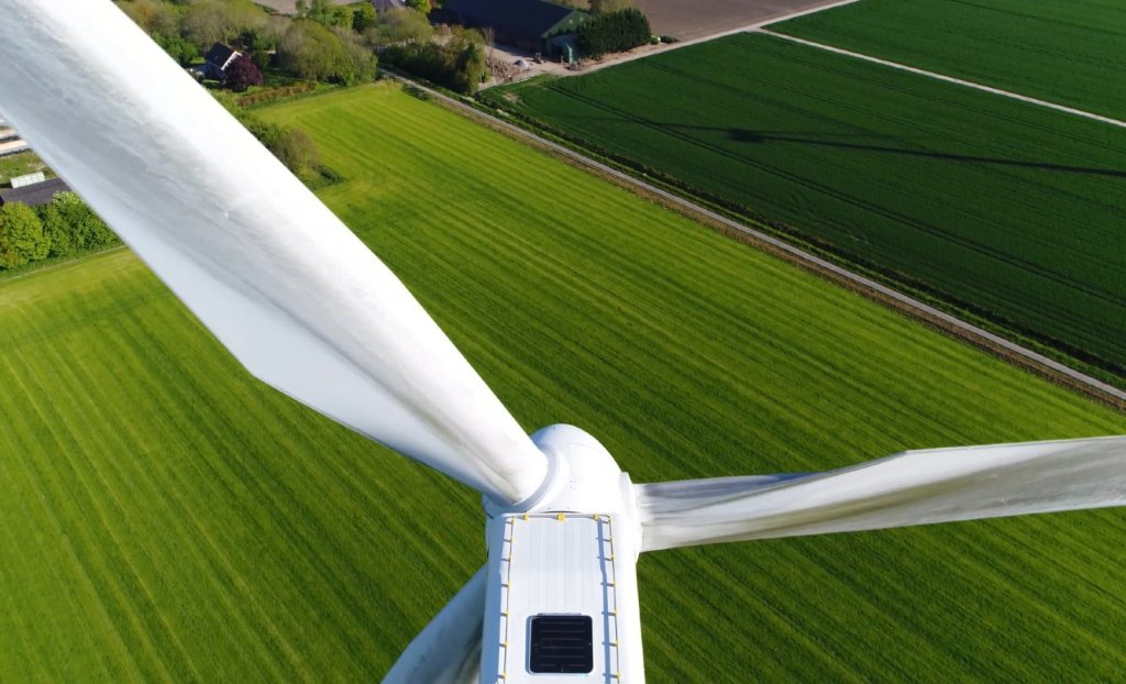 A wind turbine overlooking a field.