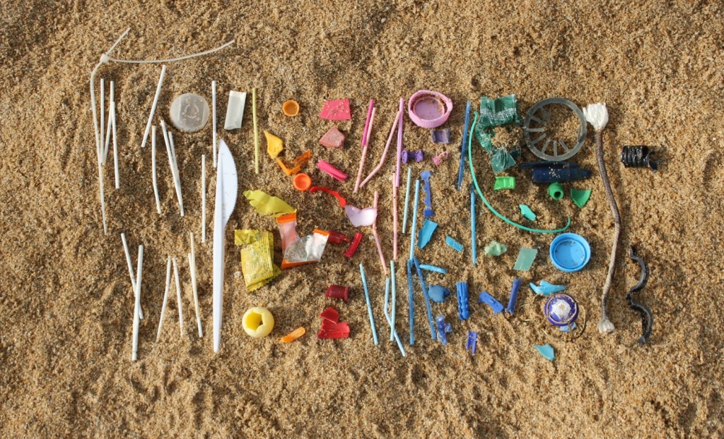 A rainbow of plastic waste on a beach.