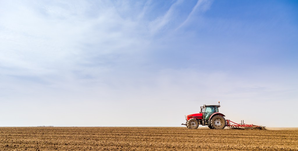 Farmer in tractor preparing land with seedbed cultivator