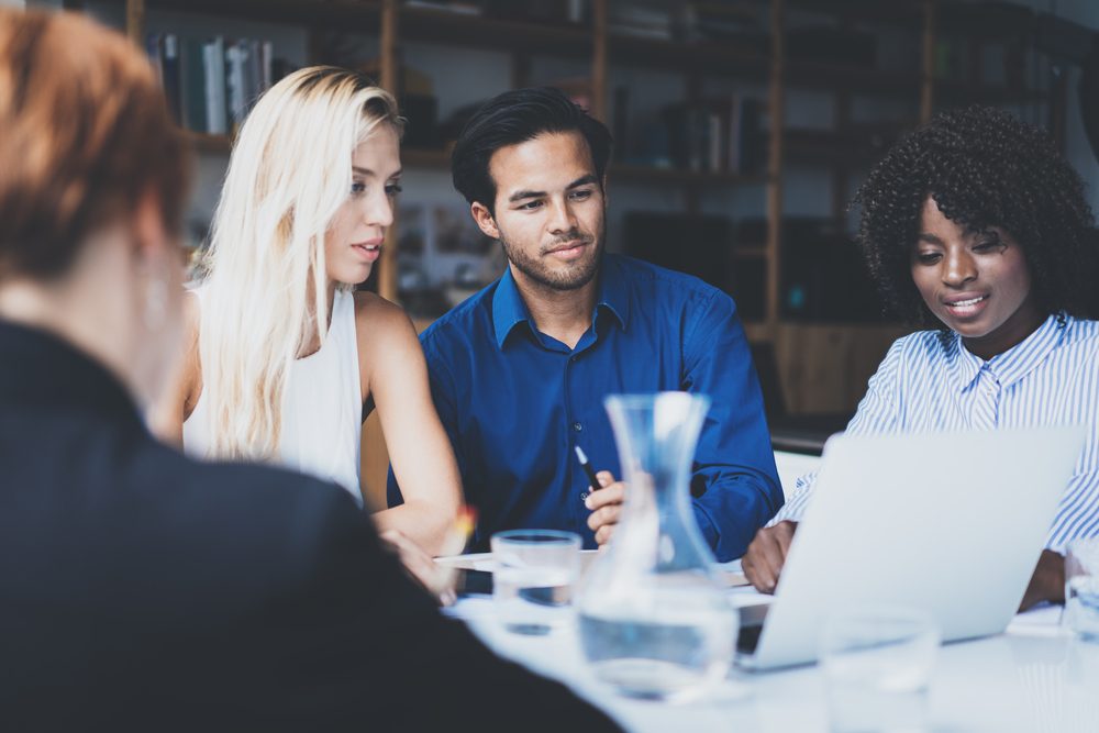 Coworkers look at laptop screen together