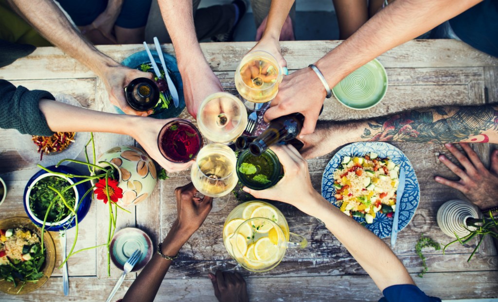 Arms toasting at a table