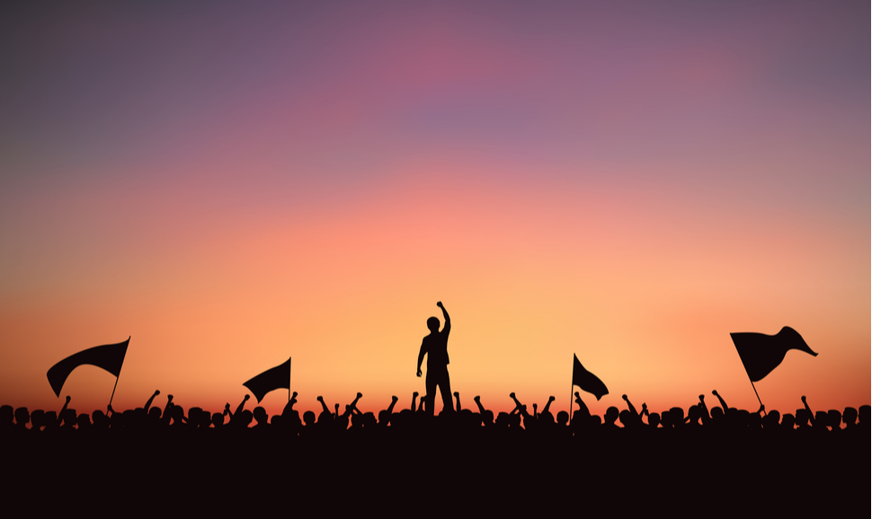 Silhouette group of people at protest with raised fist and flags