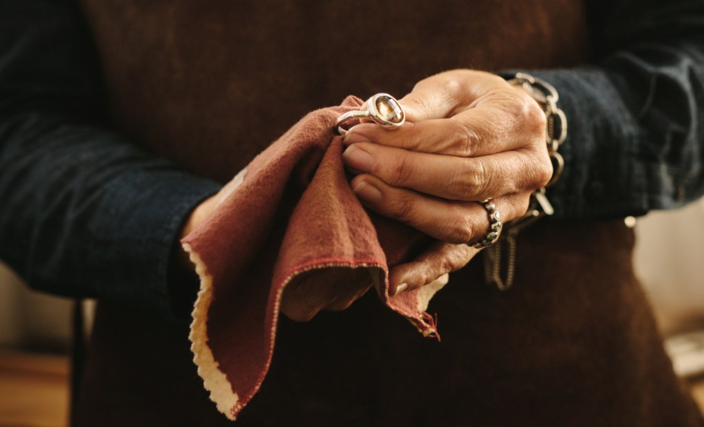 A woman's hands polishing an artisanal ring.