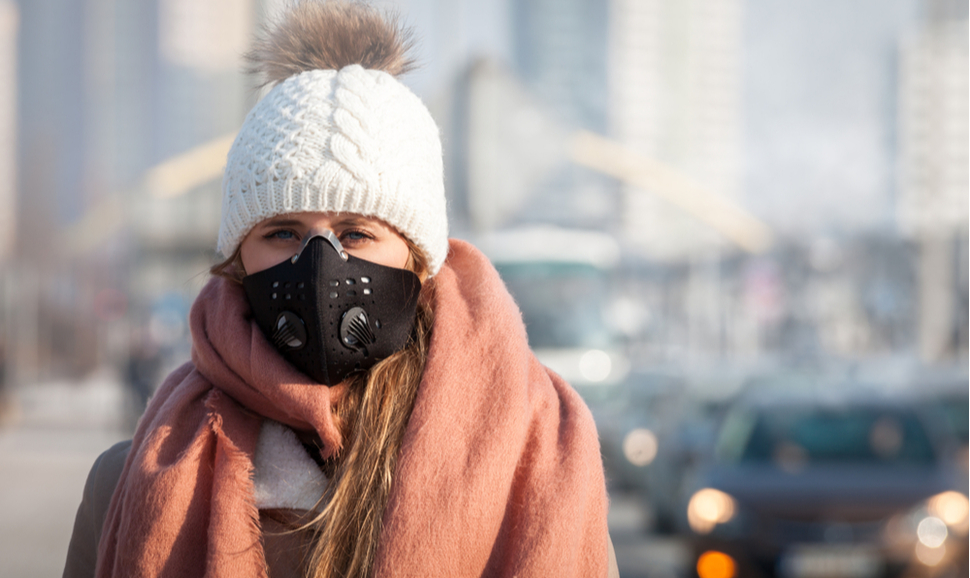 Young woman wearing protective mask in the city street