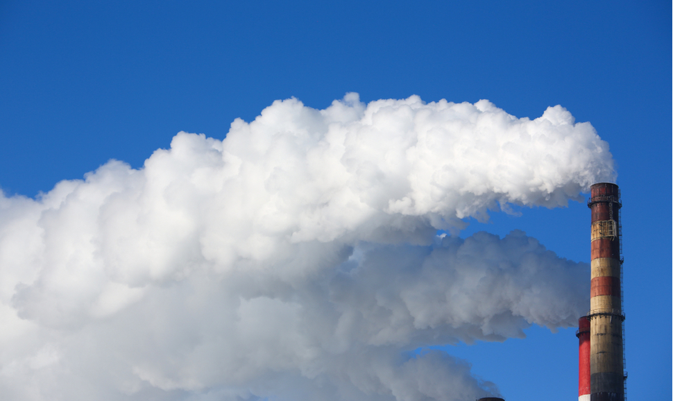 White smoke comes from pipes against blue sky