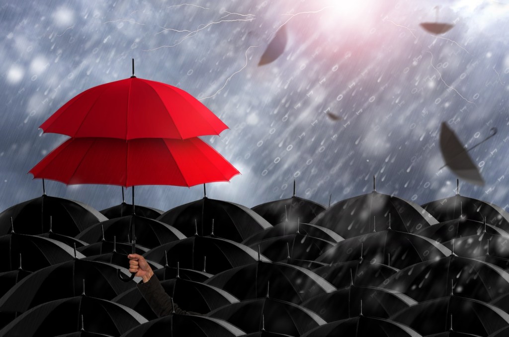 A conceptual photo of red umbrellas in a rainstorm.