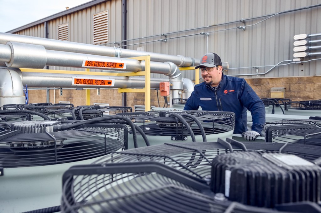 Technician inspecting rooftop equipment.