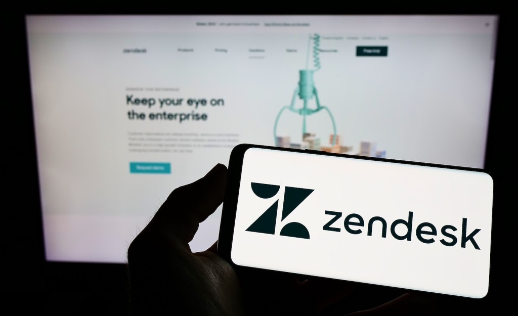 Phone with Zendesk on the screen held in front of the company's web site.