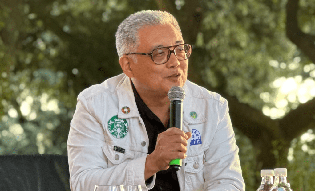 Man with glasses holding a microphone
