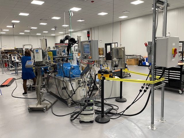 Hydefy adapted this sheet extruder machine to produce wide sheets of its mycelium "leather" material. The equipment normally would produce things such as vinyl flooring and mats. Credit: Trellis Group / Elsa Wenzel