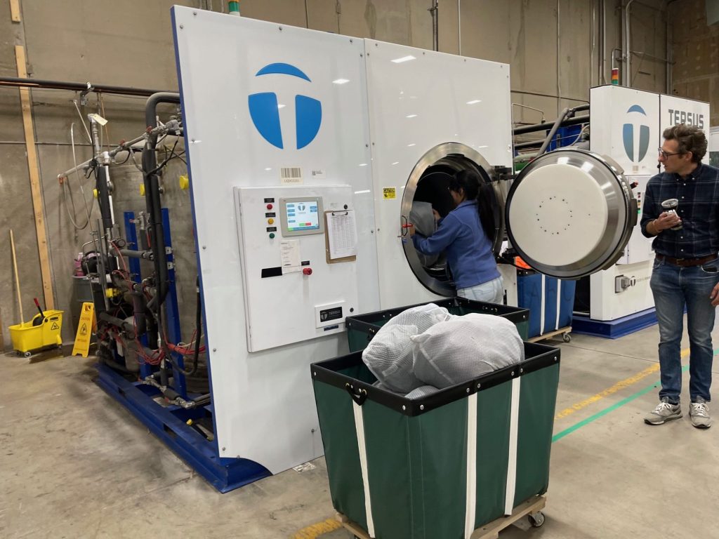 Bagged up garments enter a liquid CO2 washing machine at Tersus Solutions.