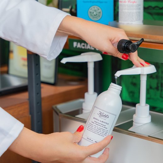 Person's hands pumping product into a container.