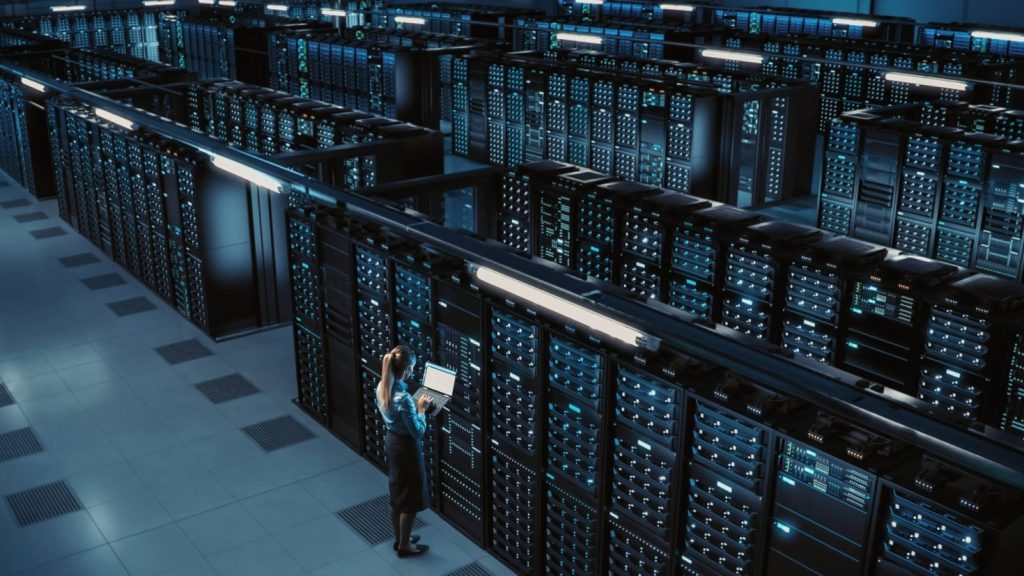 A data center with a female on a computer in it.