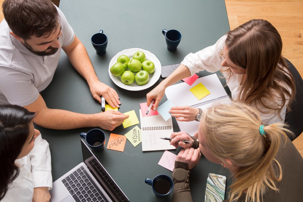 Four people brainstorming around a table at the Normative office in Stockholm.