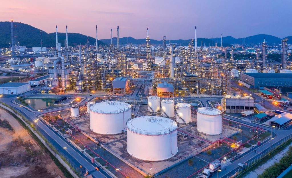 Aerial view of refinery and oil storage tanks at dusk.