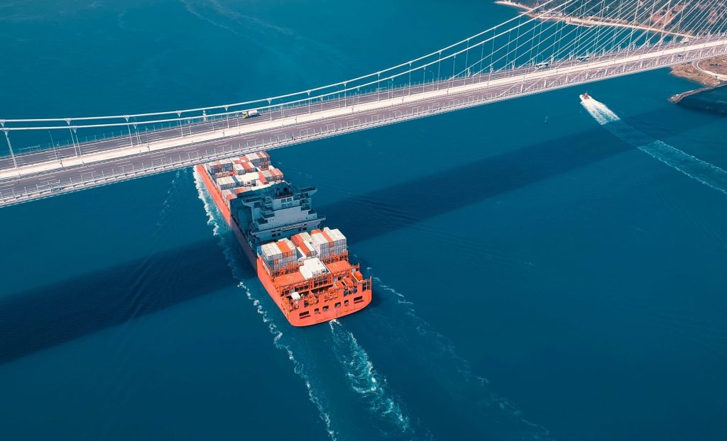 Large container ship sails under the YSS Cable Bridge.