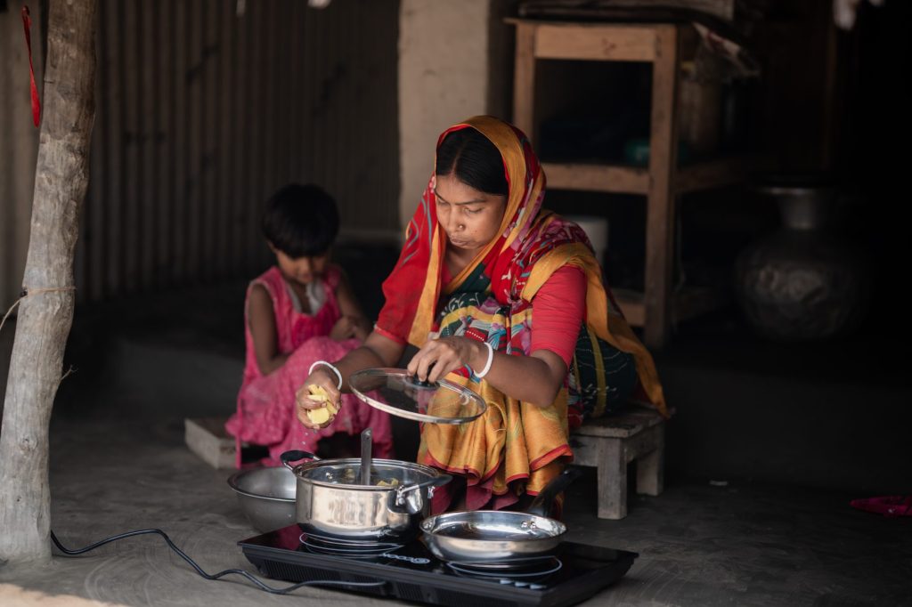 A Bangladeshi woman cooks on an electric stove supplied by STEC.