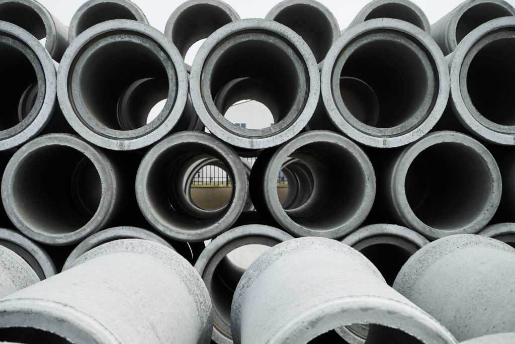 Stacked cement pipes at concrete factory.