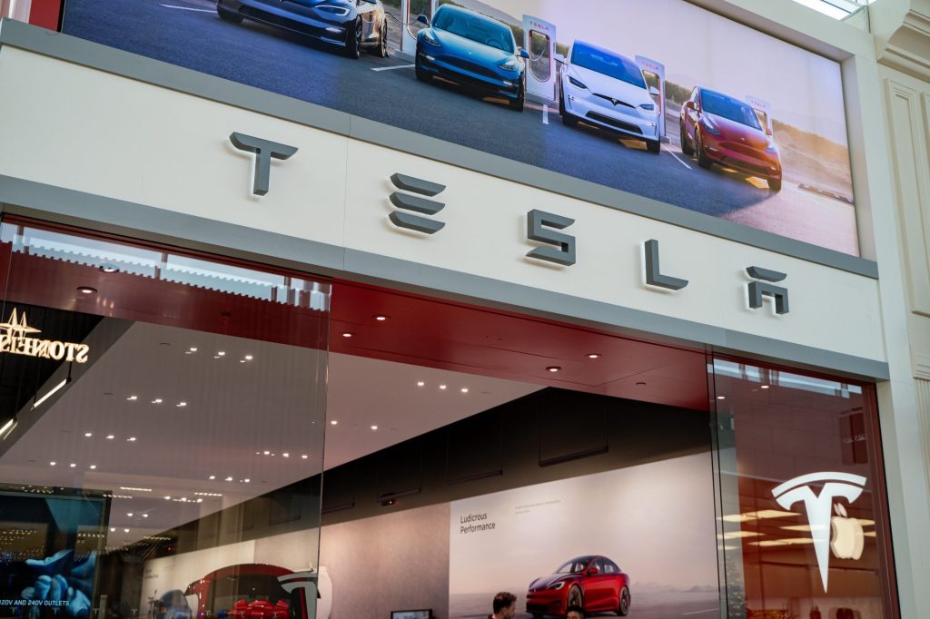 Close up of Tesla storefront signage at shopping mall.