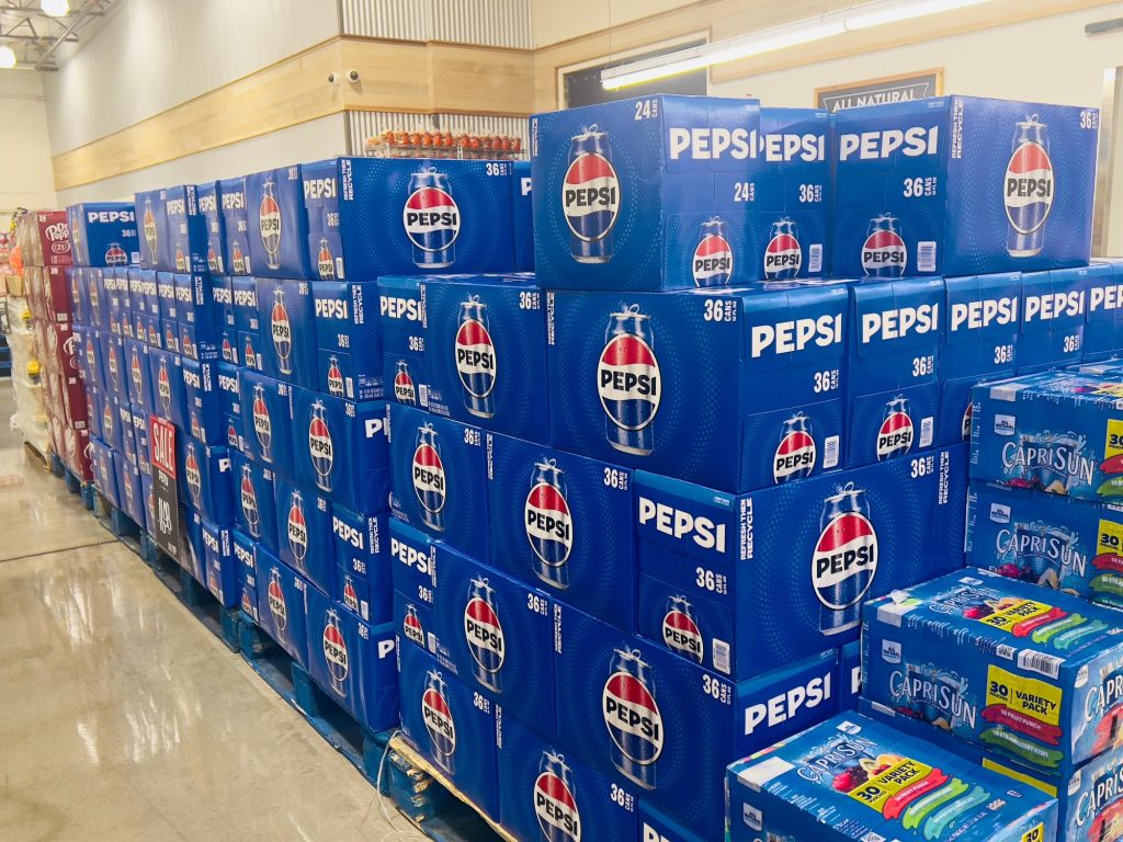 Pile of cases of canned Pepsi sodas for sale at a local supermarket aisle